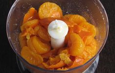 a food processor filled with oranges on top of a table