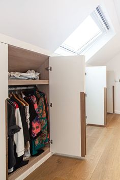 an open closet with clothes hanging in it