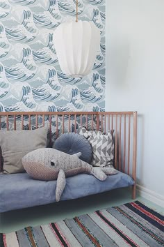 a bed with pillows on top of it in front of a wallpapered background