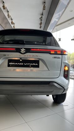 the rear end of a white suv in a showroom