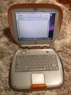 an open laptop computer sitting on top of a carpet