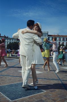 two people hugging each other in the middle of a plaza