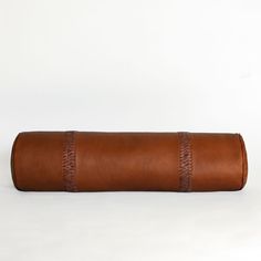 a brown leather roll on a white background