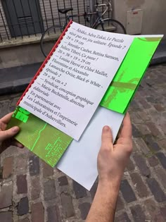 a person holding up a piece of paper with writing on it