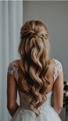 the back of a bride's head with long, wavy hair in her wedding dress