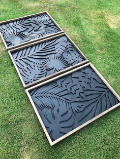 three large metal trays sitting on top of green grass