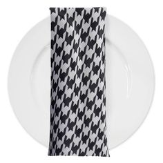 a white plate topped with a black and white napkin