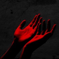 two hands reaching up into the air with red light coming from their fingertipss on a black background