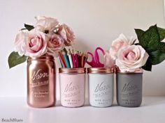 three mason jars with flowers and scissors in them