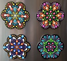 four colorful flowers painted on the side of a refrigerator