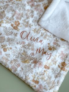 a blanket with the name julia may written on it and a white napkin next to it