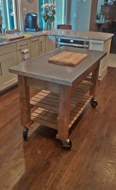 a kitchen island made out of pallet wood with wheels on the bottom and a cutting board on top