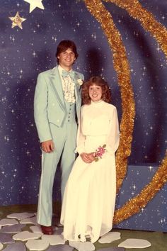 a man and woman posing for a photo in front of a wall with stars on it