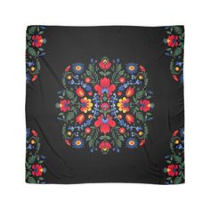 a black background with colorful flowers and leaves in the center, on top of a blanket