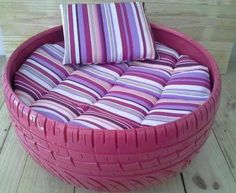 a pink basket with striped pillows on it