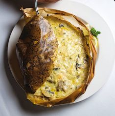 a white plate topped with food next to a knife and fork on top of a table