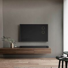 a living room with a large television on top of a wooden entertainment center in front of a striped wall