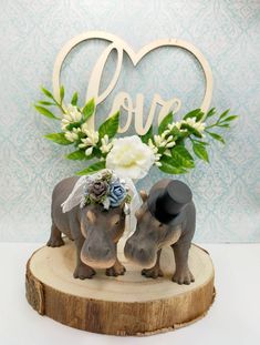 two elephants are standing next to each other in front of a sign that says love