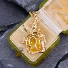 This intriguing citrine pendant features an oval checkerboard cut citrine being cradled by a woman in yellow gold and white gold flowers with diamond accents. The pendant is crafted in 14k gold. We have added an 18 inch long 14k yellow gold rounded box chain weighing approximately 3 grams. White Gold Flowers, Citrine Pendant, Round Box, Gold Flowers, Box Chain, Citrine, A Woman, Yellow Gold, White Gold