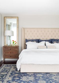 a bedroom with a large bed, dresser and mirror in it's center area