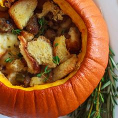 a pumpkin filled with bread and stuffing sitting on top of a table