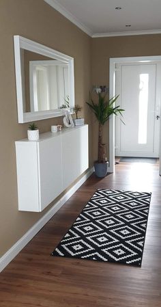 a large black and white rug sitting on top of a hard wood floor next to a doorway