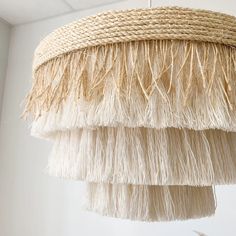 a chandelier made out of straw and jute is hanging from the ceiling