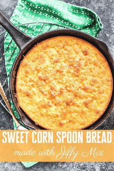 a skillet with some food in it on top of a green cloth and spoons