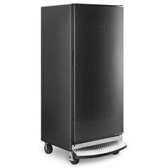 a black refrigerator sitting on top of a white floor next to a metal rack with wheels