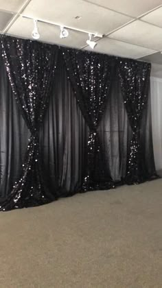 an empty room with black sequin curtains