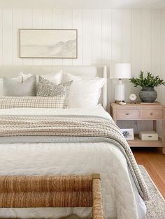 a bedroom with white walls and wood floors