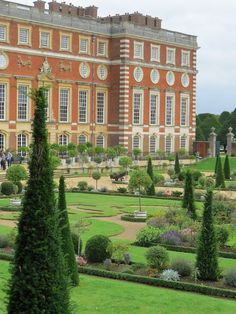 a large red brick building surrounded by trees and bushes