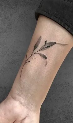 a woman's wrist with a small flower tattoo on the left side of her arm