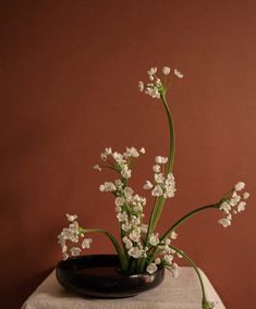 a black bowl with white flowers in it