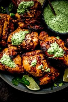 grilled chicken with green sauce and garnishes on a plate, ready to be eaten