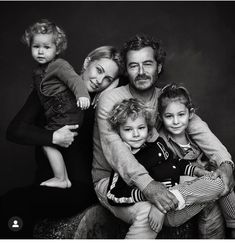 a black and white photo of a family posing for a portrait with their two children