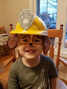 a young boy wearing a hard hat and glasses with a dog's paw on it