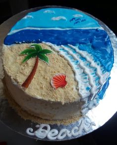 there is a cake that has been decorated with a beach scene and palm tree on it