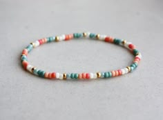 a beaded bracelet with multicolored beads on a white surface, close up