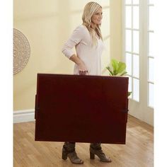 a woman is holding a large piece of furniture