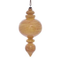 a wooden ornament hanging from a string on a white background with clippings