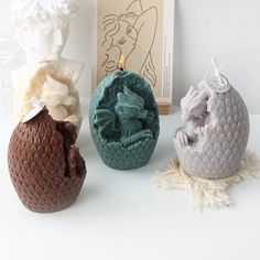 three different colored vases sitting next to each other on a table with a book in the background