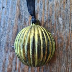 an ornament hanging on a wooden surface with a black cord attached to it