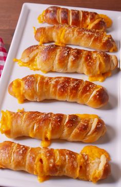 four croissants on a white plate with cheese