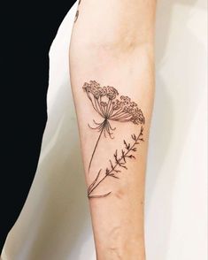 a woman's arm with a flower tattoo on it