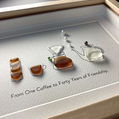 three pieces of jewelry are displayed in a shadow box with the words from one coffee to forty years of friendship