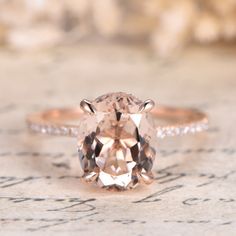 an engagement ring with a large peach colored diamond in the center and side stones around it