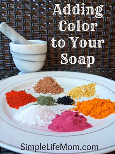 a white plate topped with lots of different colored powders next to a mortar bowl