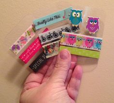 a hand is holding several different types of hair clips with owls on them, one has a name tag and the other has an owl sticker that says really like this