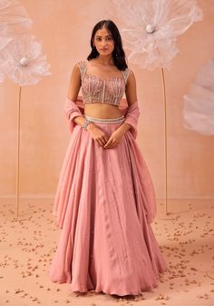 Make a stunning impression with this blouse featuring all-over 3D applique work, embellished with pearls and zari detailing. Paired with a matching skirt and dupatta, this ensemble blends intricate craftsmanship with sophisticated design, perfect for any special occasion. Crop Top Lehenga Wedding Indian Fashion, Crop Top Lehenga Wedding, Pink Georgette Lehenga, Baby Pink Bridesmaids Dresses, Blush Pink Lehenga, Plain Lehenga, Embellished Lehenga, Bridesmaid Dresses Indian, Peach Lehenga